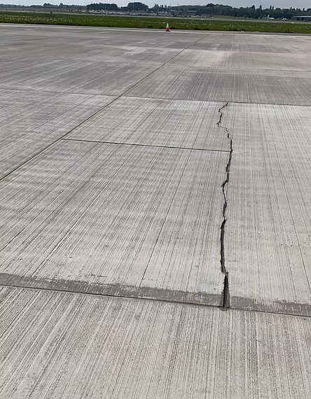 Large jagged crack running across the surface of a concrete slab before repair