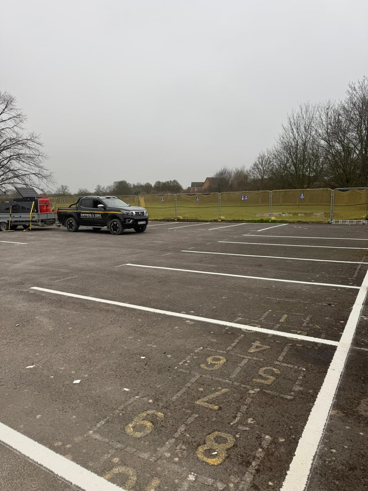 Shepherd and Sons Contracting pickup and trailer in a newly line-marked car park with temporary fencing