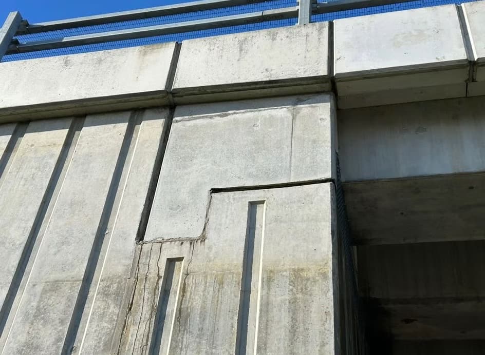 Underside of a concrete structure showing precast beams and slabs with a visible crack