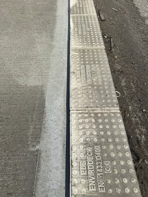 Close-up of installed slot drainage channel covers set into a concrete surface